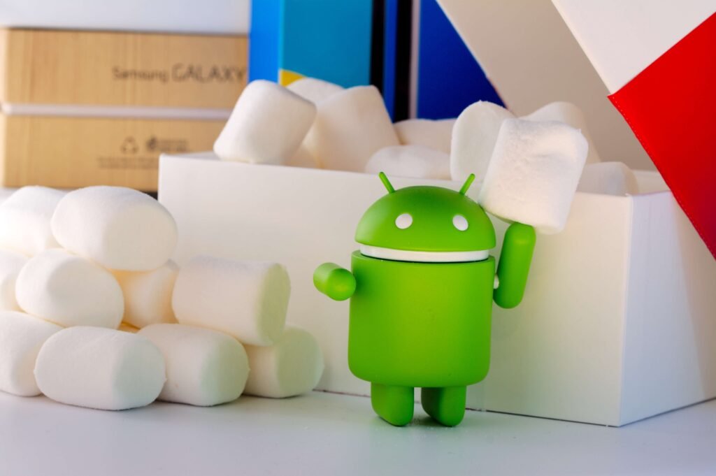Boneco verde do Android segurando marshmallow, representando o sistema operacional responsável pelos apps mais baixados da Play Store.